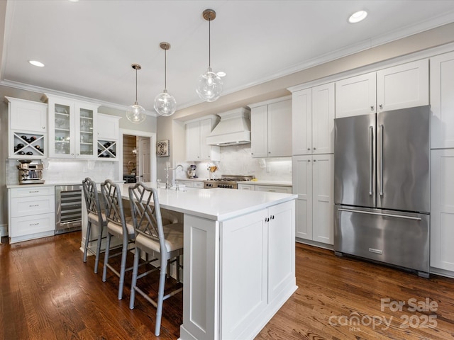kitchen with freestanding refrigerator, wine cooler, premium range hood, decorative backsplash, and crown molding