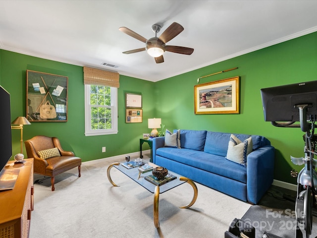 living area featuring ceiling fan, baseboards, ornamental molding, and carpet floors