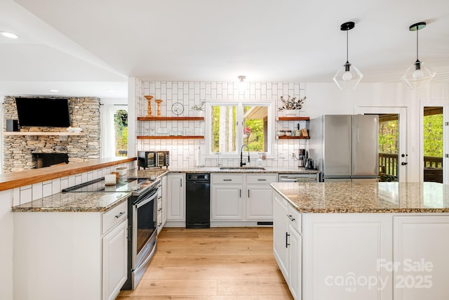 kitchen featuring stainless steel appliances, open shelves, a sink, light wood-type flooring, and backsplash