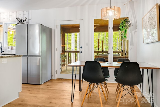 dining space featuring light wood-style floors, a chandelier, and plenty of natural light