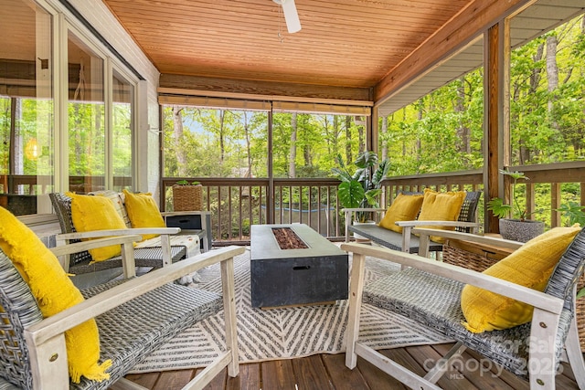sunroom featuring an outdoor living space with a fire pit