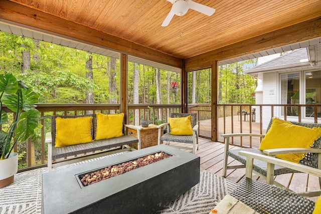 sunroom with a fire pit and ceiling fan