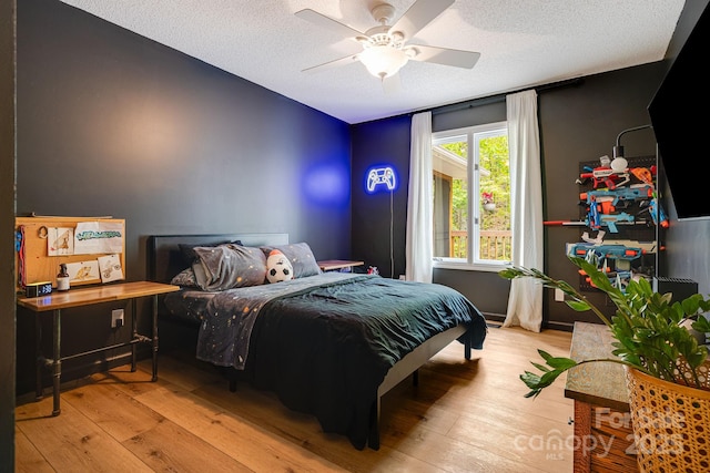 bedroom with wood-type flooring, a textured ceiling, and ceiling fan