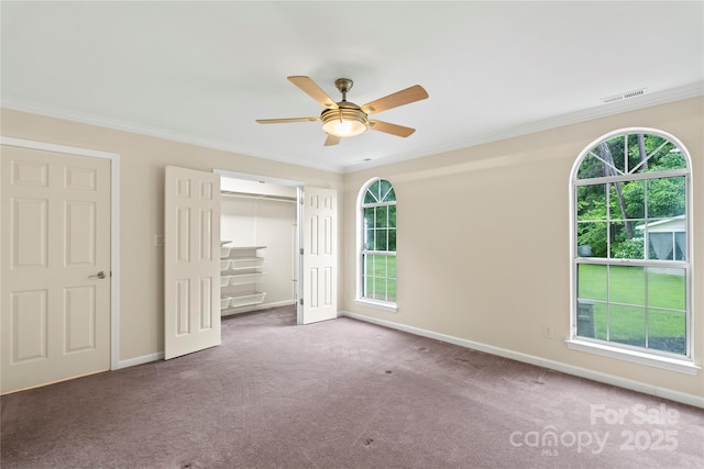 unfurnished bedroom featuring carpet floors, ornamental molding, baseboards, a closet, and ceiling fan