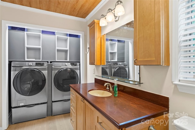 washroom with washing machine and clothes dryer, ornamental molding, wooden ceiling, and light wood-type flooring