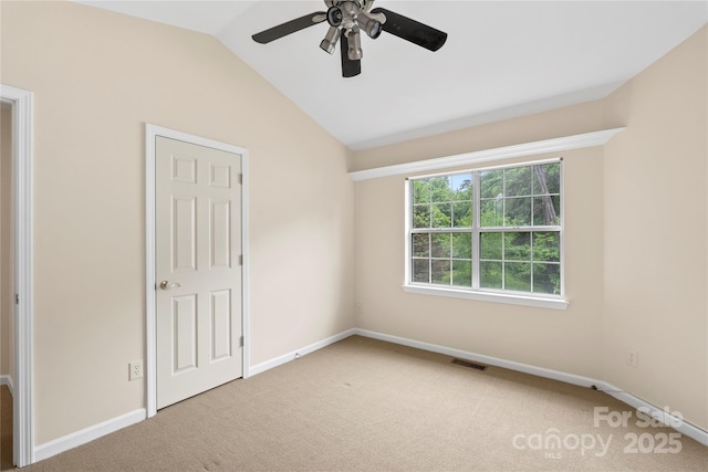 unfurnished bedroom featuring carpet flooring, vaulted ceiling, baseboards, and a ceiling fan