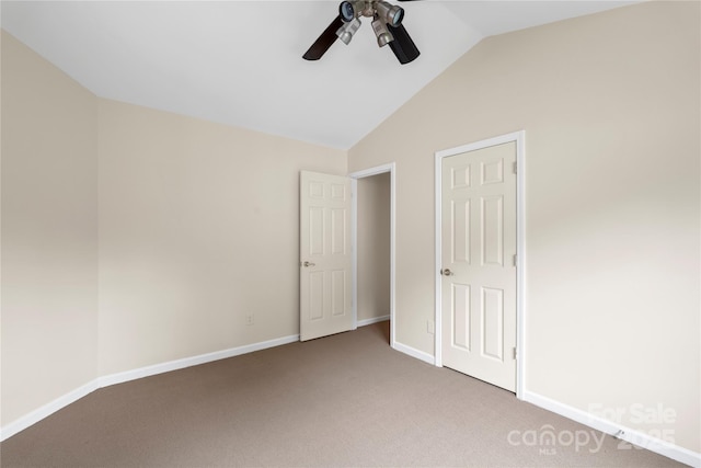 unfurnished bedroom featuring light carpet, baseboards, lofted ceiling, and ceiling fan