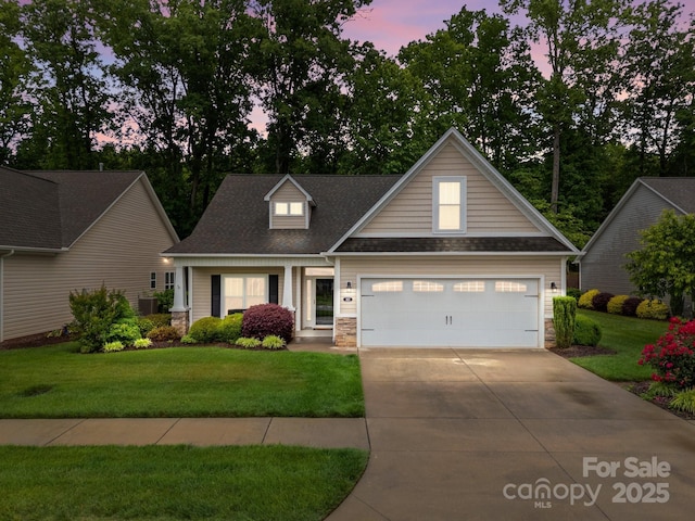 422 Drake Ln, Salisbury, NC 28146 - view of front facade featuring a front lawn, concrete driveway, stone siding, a garage, and roof with shingles