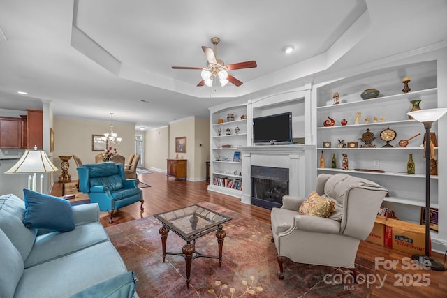 422 Drake Ln, Salisbury, NC 28146 - living area featuring wood finished floors, ceiling fan, a raised ceiling, a fireplace, and a chandelier