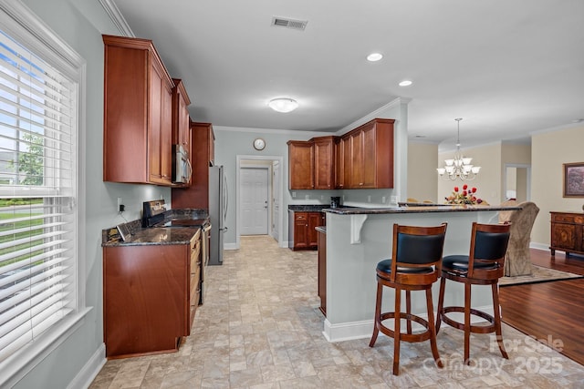 422 Drake Ln, Salisbury, NC 28146 - kitchen featuring stainless steel appliances, baseboards, a breakfast bar, crown molding, and a chandelier