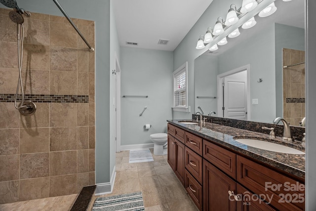 422 Drake Ln, Salisbury, NC 28146 - bathroom with a tile shower, toilet, double vanity, and baseboards