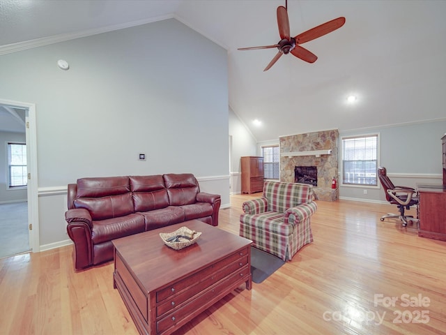 4620 Binwhe Ln, Gastonia, NC 28052 - living room featuring vaulted ceiling, a ceiling fan, light wood-style flooring, a stone fireplace, and baseboards