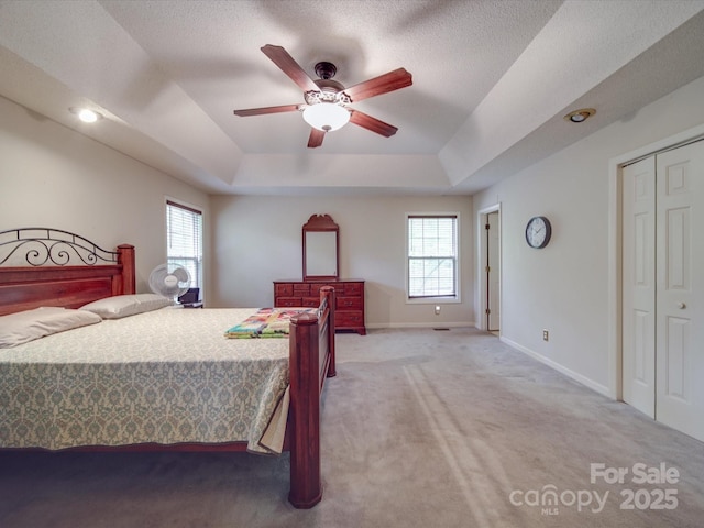 4620 Binwhe Ln, Gastonia, NC 28052 - bedroom with light colored carpet, a tray ceiling, baseboards, ceiling fan, and a closet