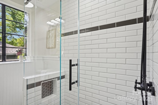 bathroom with a stall shower and wainscoting