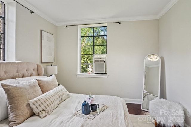 bedroom featuring ornamental molding, wood finished floors, baseboards, and cooling unit