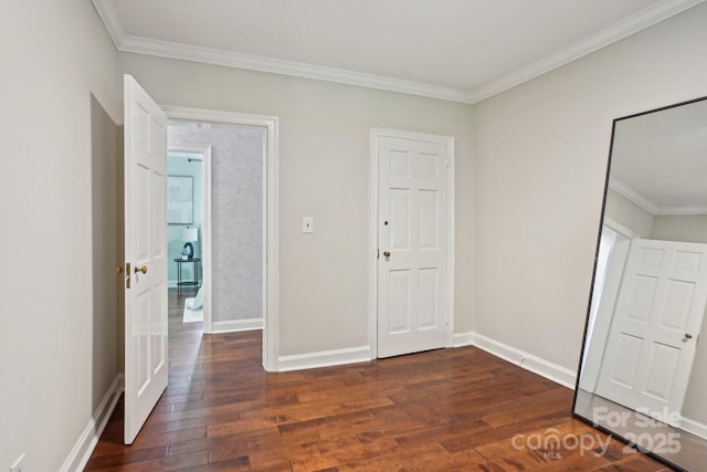 unfurnished bedroom featuring dark wood finished floors, crown molding, and baseboards