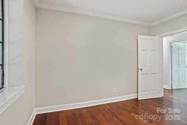 empty room featuring dark wood-type flooring, crown molding, and baseboards