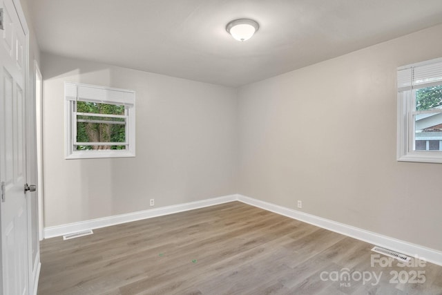empty room with light wood-style floors and baseboards