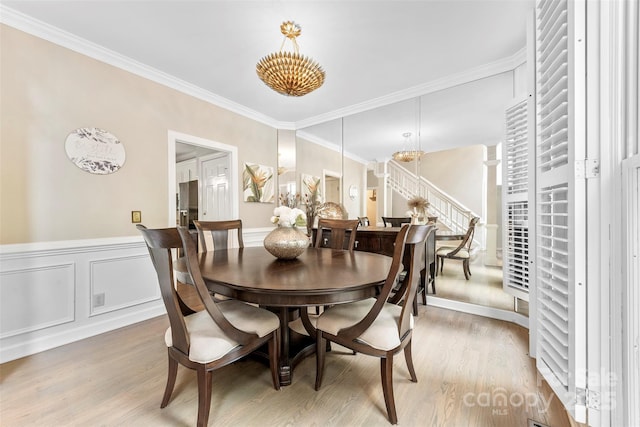 4846 Deer Cross Trl, Charlotte, NC 28269 - dining room with light wood-style flooring, a chandelier, a wainscoted wall, and crown molding