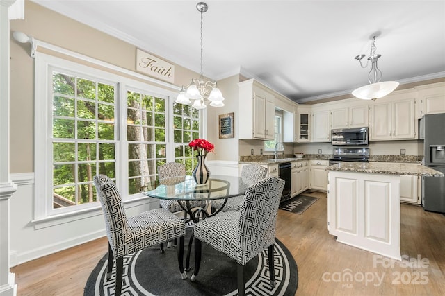 4846 Deer Cross Trl, Charlotte, NC 28269 - kitchen with appliances with stainless steel finishes, a chandelier, light wood-type flooring, crown molding, and light stone countertops