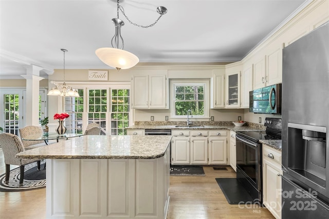4846 Deer Cross Trl, Charlotte, NC 28269 - kitchen with appliances with stainless steel finishes, light wood-style floors, light stone counters, a center island, and a sink