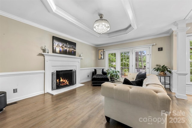 4846 Deer Cross Trl, Charlotte, NC 28269 - living area featuring decorative columns, crown molding, a lit fireplace, wood finished floors, and a raised ceiling