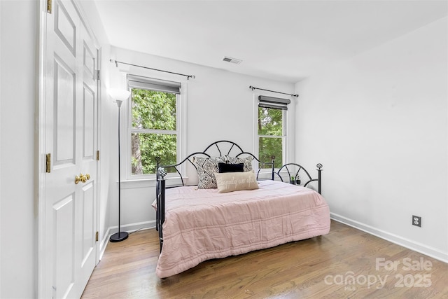 4846 Deer Cross Trl, Charlotte, NC 28269 - bedroom with multiple windows, wood finished floors, and baseboards