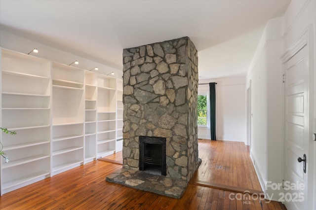 31 Jefferson Dr, Asheville, NC 28801 - unfurnished living room featuring wood-type flooring, baseboards, a stone fireplace, and built in shelves