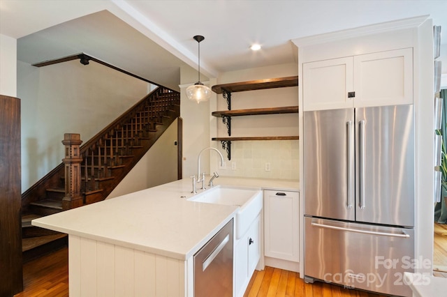 31 Jefferson Dr, Asheville, NC 28801 - kitchen with stainless steel appliances, open shelves, light wood-style flooring, a sink, and light countertops