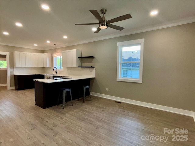 85 Archer St, Granite Falls, NC 28630 - kitchen featuring crown molding, a breakfast bar area, a sink, a peninsula, and light countertops