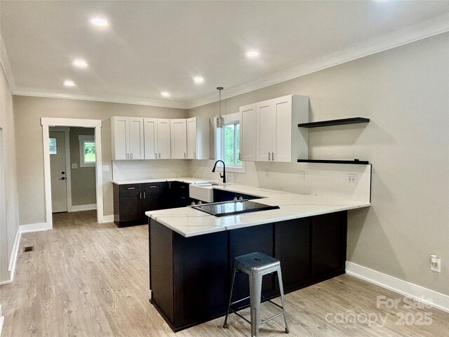 85 Archer St, Granite Falls, NC 28630 - kitchen featuring open shelves, black electric cooktop, ornamental molding, a peninsula, and a breakfast bar