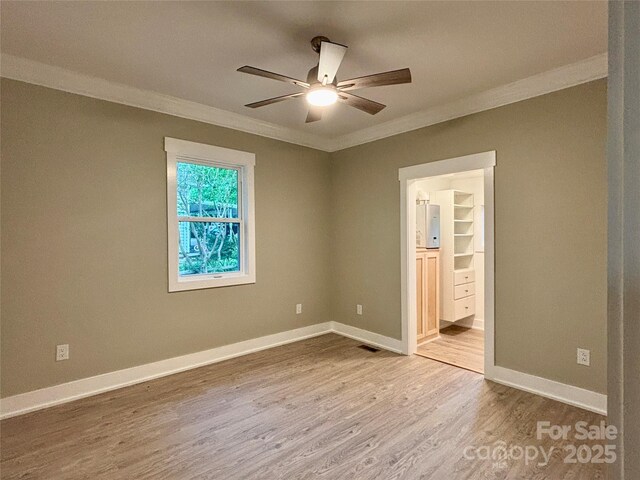 85 Archer St, Granite Falls, NC 28630 - unfurnished bedroom featuring ornamental molding, wood finished floors, connected bathroom, baseboards, and a ceiling fan
