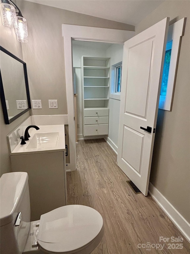85 Archer St, Granite Falls, NC 28630 - bathroom featuring toilet, wood finished floors, vanity, and baseboards