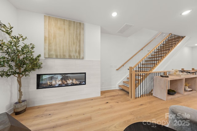 158 Mattoon St, Charlotte, NC 28216 - living area with wood finished floors, stairway, a tiled fireplace, and recessed lighting
