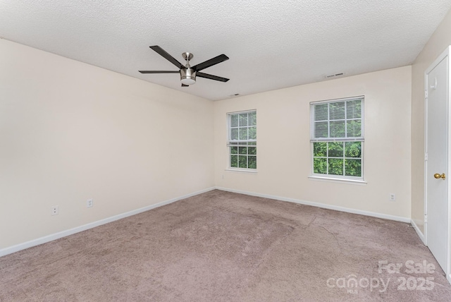 spare room featuring ceiling fan, carpet flooring, baseboards, and a textured ceiling