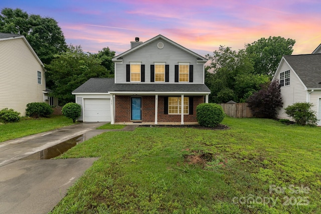 traditional home featuring an attached garage, concrete driveway, covered porch, a chimney, and brick siding