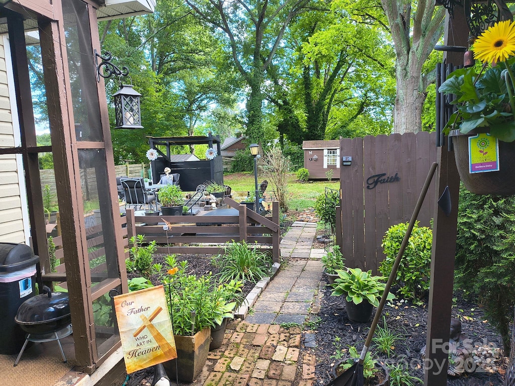 view of yard with fence, a shed, and an outbuilding