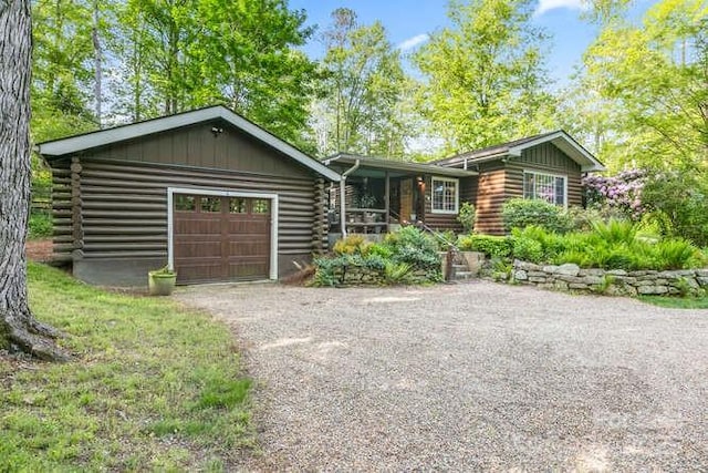 20 Deva Gln, Asheville, NC 28804 - log cabin with an attached garage, log exterior, driveway, and board and batten siding