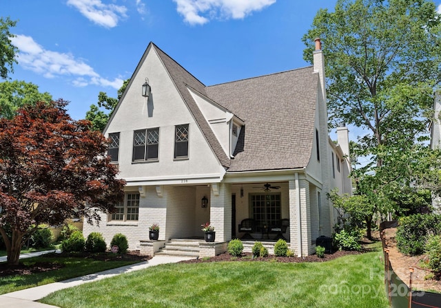 236 Wales Ave, Charlotte, NC 28209 - view of front of home with a chimney, a front lawn, brick siding, and ceiling fan