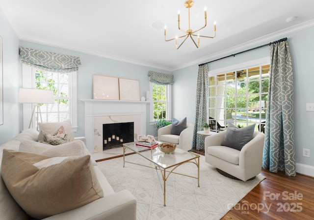 236 Wales Ave, Charlotte, NC 28209 - living room with ornamental molding, a chandelier, wood finished floors, baseboards, and a high end fireplace