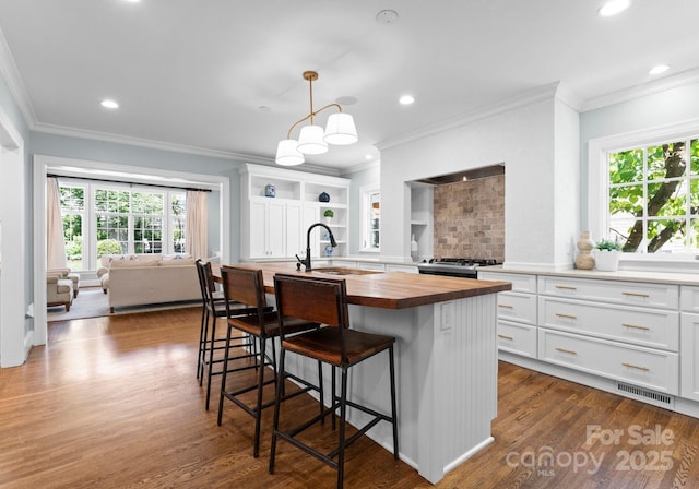 236 Wales Ave, Charlotte, NC 28209 - kitchen featuring butcher block countertops, a sink, open shelves, plenty of natural light, and ornamental molding