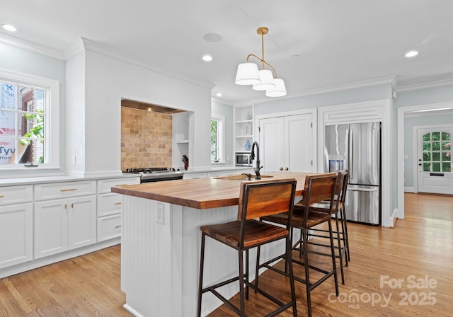 236 Wales Ave, Charlotte, NC 28209 - kitchen with stainless steel fridge, butcher block counters, light wood-style floors, crown molding, and a sink