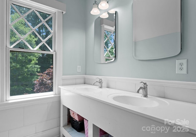 236 Wales Ave, Charlotte, NC 28209 - bathroom with plenty of natural light, double vanity, and a wainscoted wall