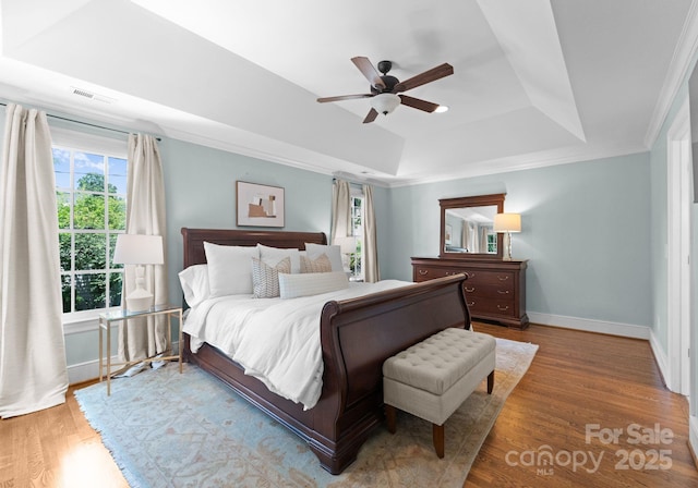 236 Wales Ave, Charlotte, NC 28209 - bedroom with a raised ceiling, multiple windows, wood finished floors, baseboards, and crown molding