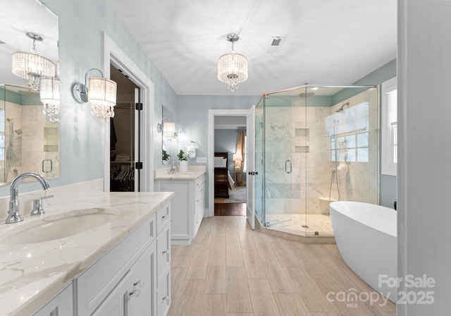 236 Wales Ave, Charlotte, NC 28209 - full bath with a chandelier, a shower stall, and two vanities