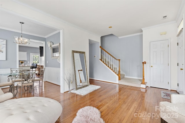 9775 Mallard Glen Dr, Charlotte, NC 28262 - living area with light wood-style floors, stairway, ornamental molding, a chandelier, and baseboards
