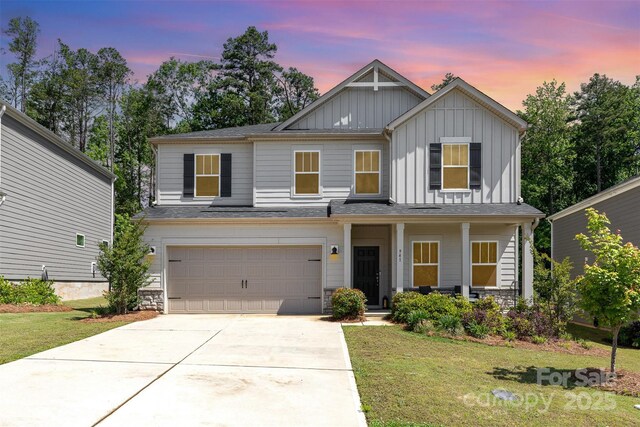 941 Rachel Anne Dr, Belmont, NC 28012 - view of front of house featuring board and batten siding, a garage, a yard, concrete driveway, and covered porch