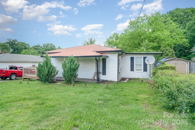 ranch-style house featuring a front yard and metal roof