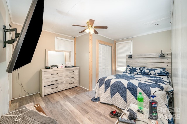 bedroom featuring light wood-style floors, crown molding, and a ceiling fan