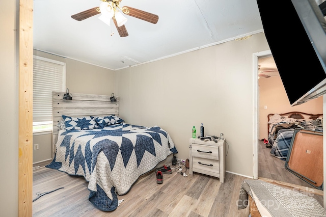 bedroom featuring wood finished floors, ornamental molding, ceiling fan, and baseboards